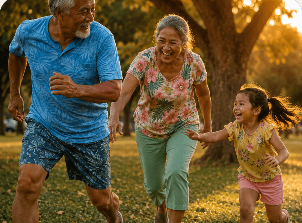 Grandparents and a young girl running and laughing together in a Hawaii park at golden hour