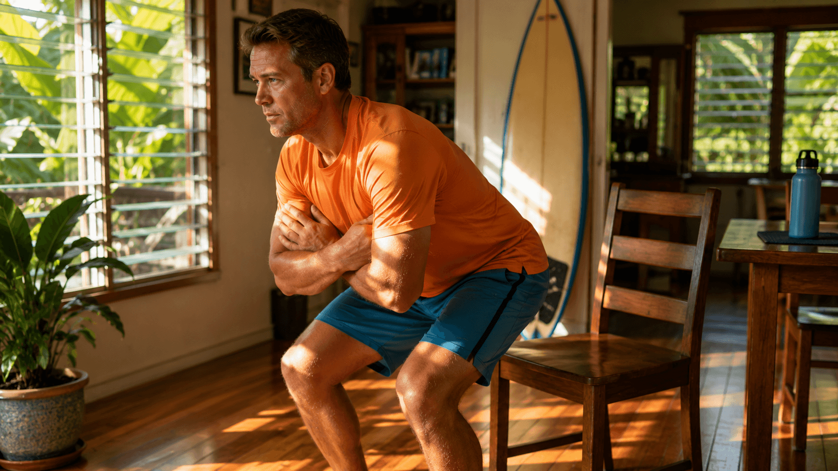 Local Hawaii man, late 40s, standing fully upright from a plain dining chair with arms crossed over his chest, caught mid-transition between sitting and standing.
