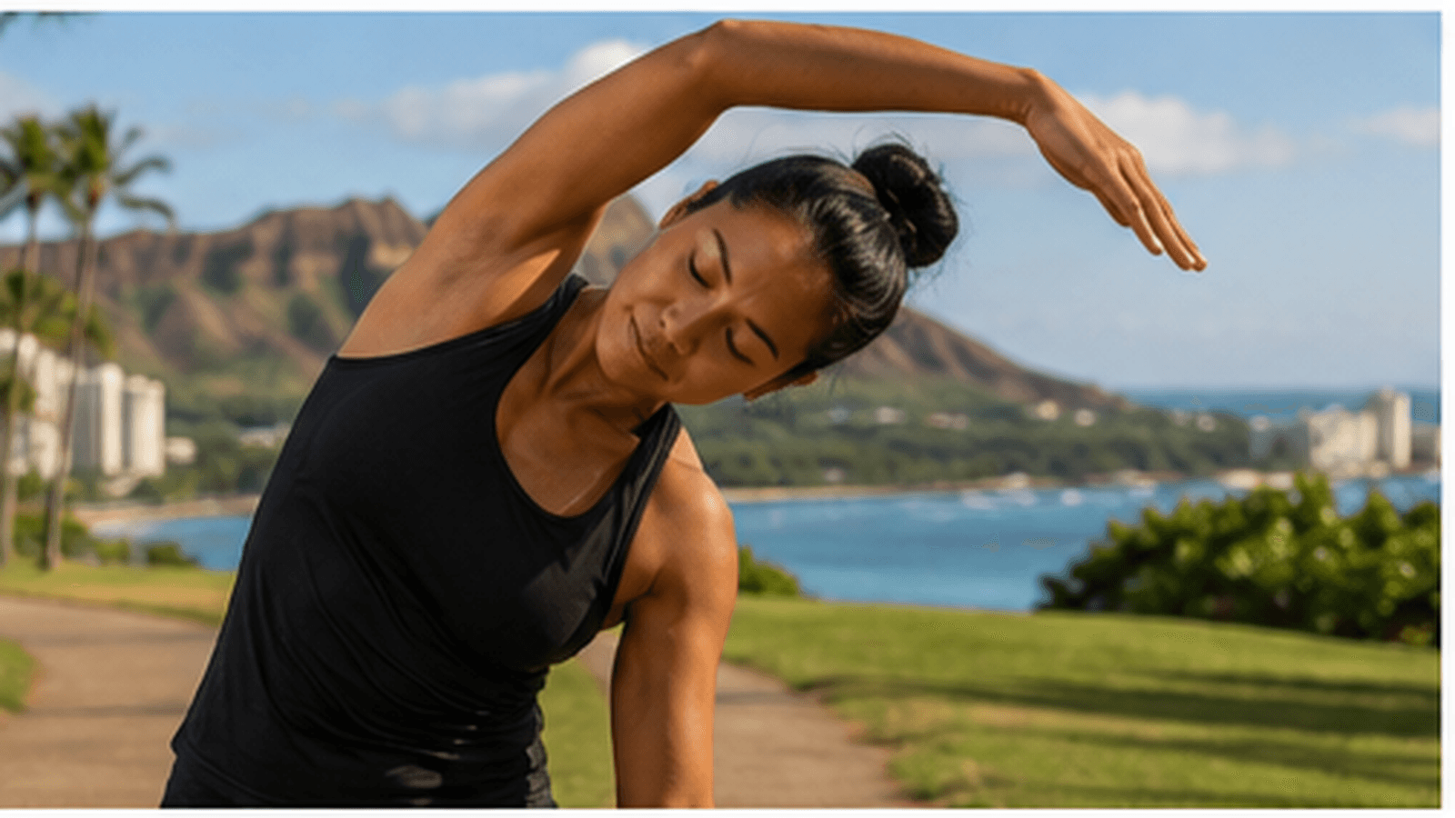 A woman doing a gentle side stretch outdoors with a coastal mountain view behind her